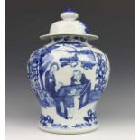 China, blauw-wit porseleinen dekselvaas, mogelijk 19e eeuw, met decor van vrouw en zotje bij hekwerk