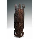 Asmat, houten sculptuur van schildpad; platte figuur met op het brede lichaam uitgesneden