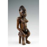 Senufo, zittend vrouwelijk figuur met handen op de knieën en lichaamstatoeages. h. 37 cm.