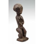 Baule, staand vrouwelijk figuur, met armen voor het lichaam en met resten van beschildering en