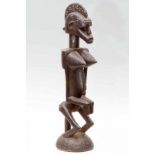 Mali, Bamana-Senufo, gezeten vrouwfiguur met geprononceerde kin, open mond, kamvormige haardracht en