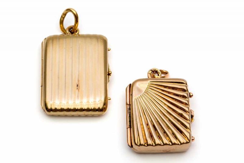 Twee 14krt. gouden geribde medaillons, 19e/20e eeuw. Beide in boekvorm bruto 7,7 gr.