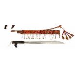 Borneo, Dayak, mandau, with beaded panel, chord and tassels. The wooden handle with carved aso-