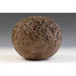 Antique carved and pierced coconut with scenery of trees and houses. Placed on loose pedestal.