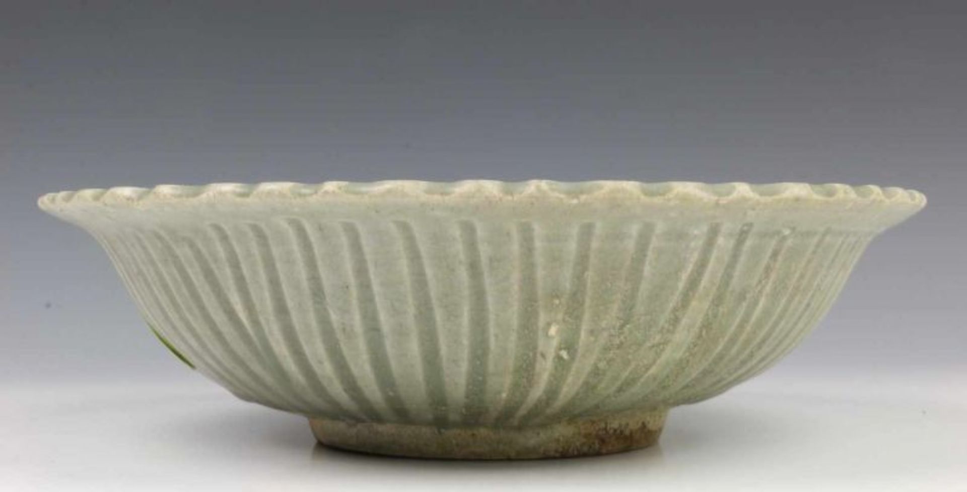 China, antiek celadon kom met ingegrifte band rond de geribde rand diam. 28 cm. [1]