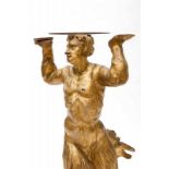 An early 18th century carved and gilded torchere; depicting Triton carrying a serpentine hexagonal