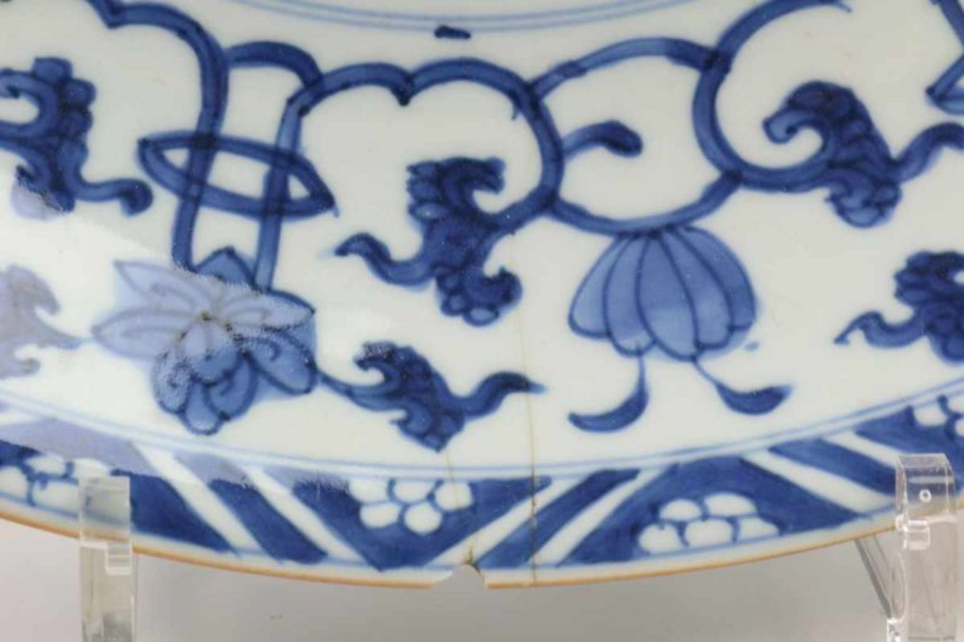 China, blauw-wit porseleinen schotel, Kangxi, met decor van bloesem, de rand met lotussen. Gemerkt - Image 2 of 3