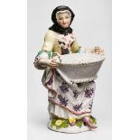 Dame mit Blumensteckschale, Meissen um 1750. Auf Felssockel sitzende Frau m. Kopftuch u.