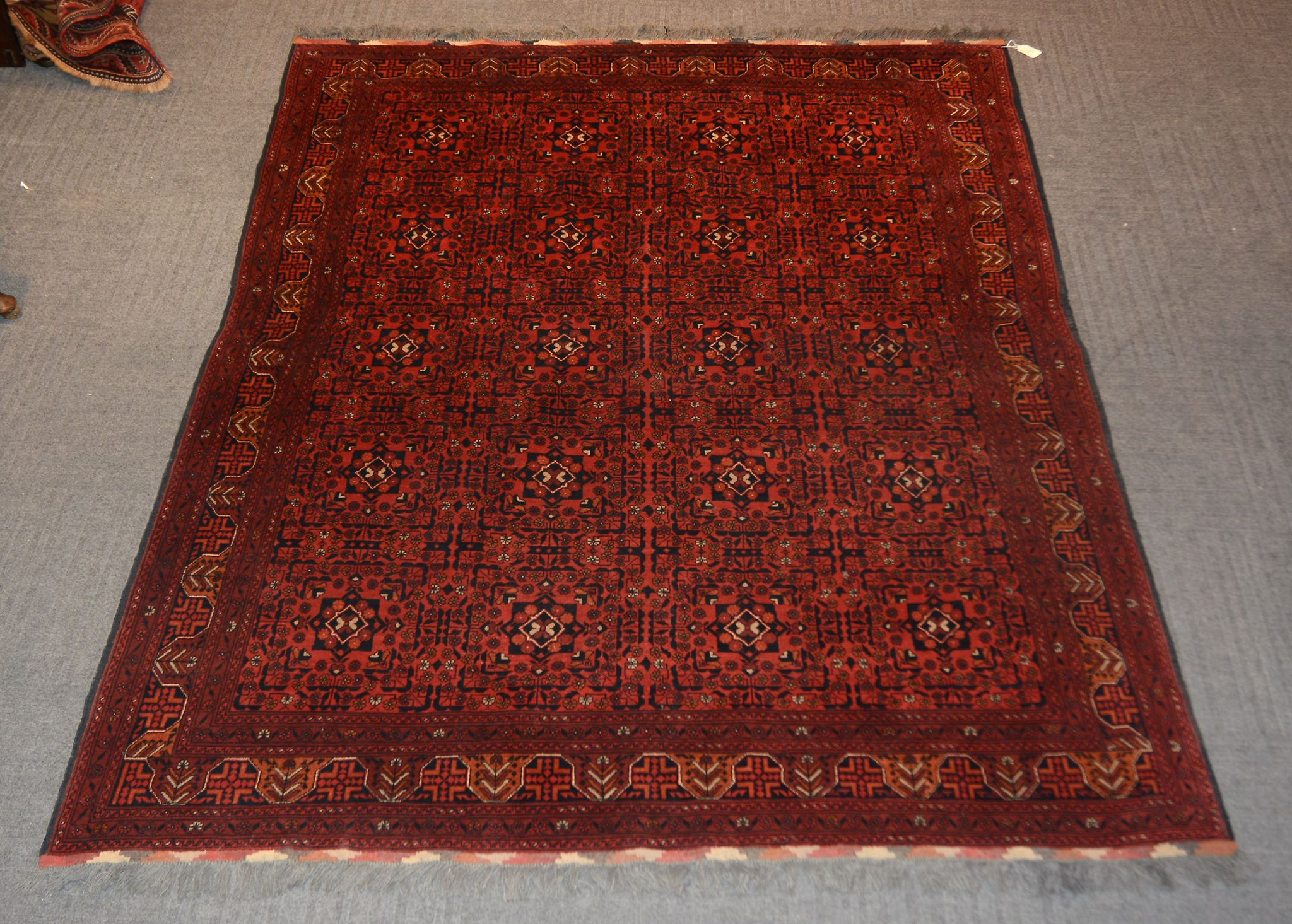 A rug in Tekke style, with a ground of stylised flowers on a red ground