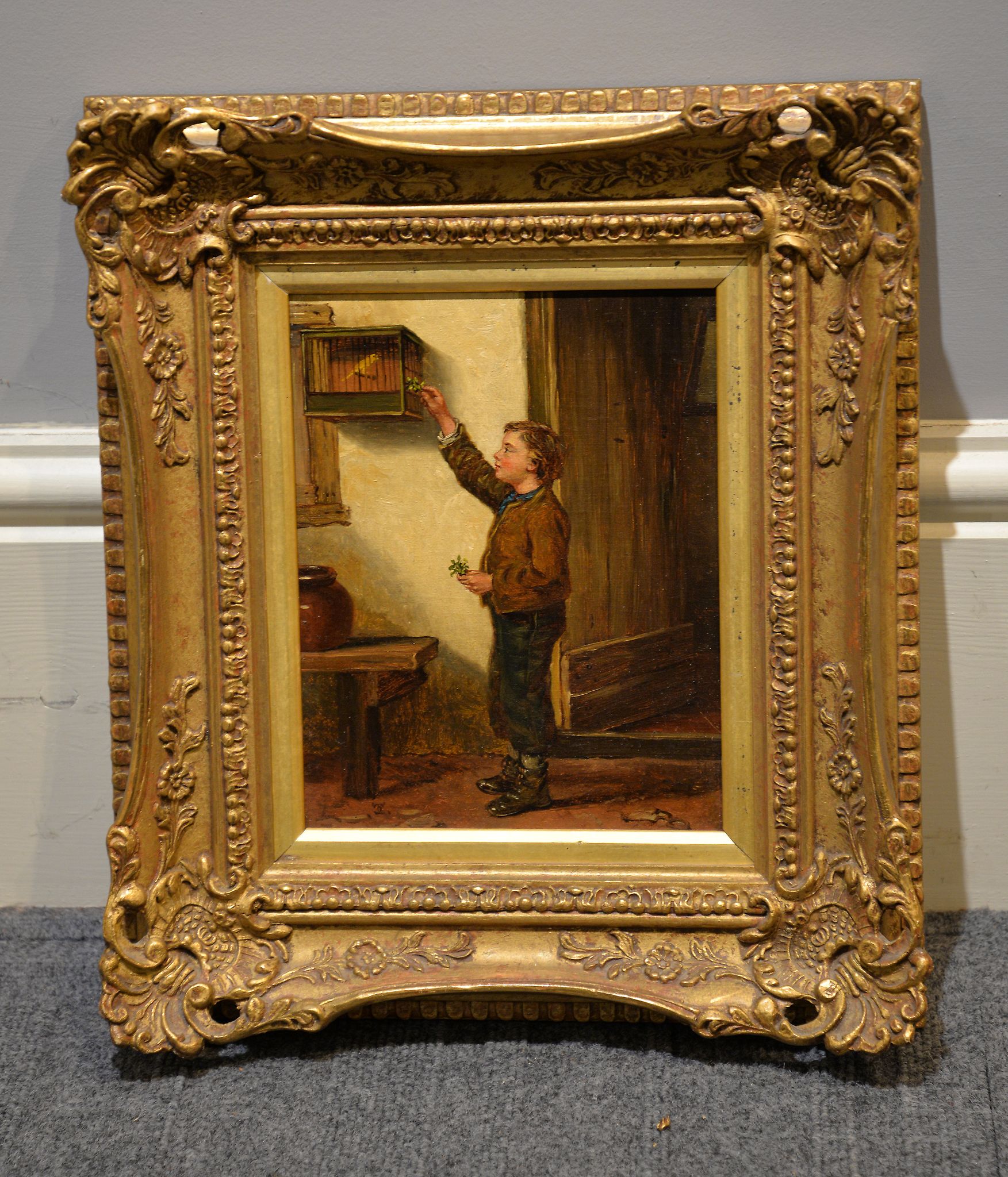 British School, 19 th century Boy feeding a canary Oil on panel Signed with