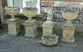 A set of four stone composition urns on plinths, 20th century, 82cm high overall