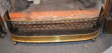 A late Regency brass and pierced steel fire fender on ball feet, 94cm long