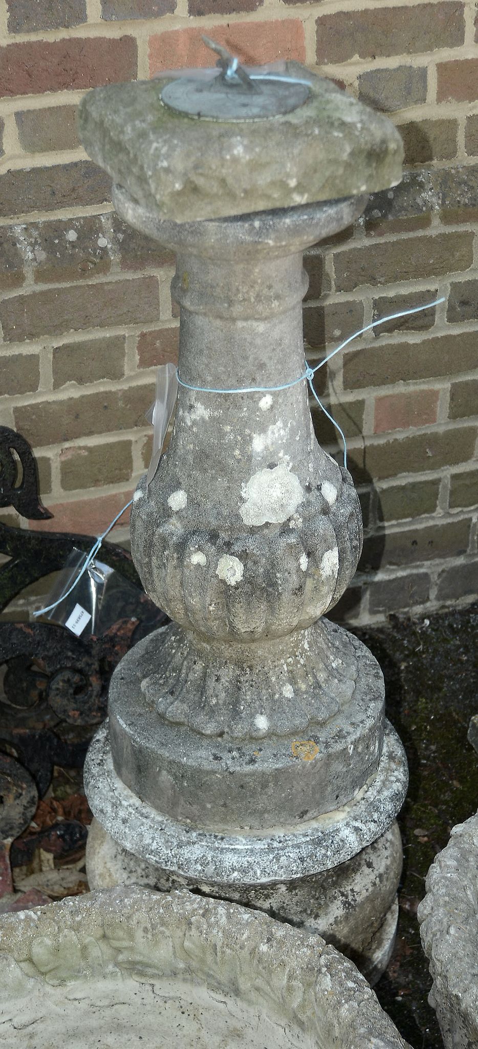 A stone composition plinth with associated metal sundial, 20th century