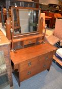 An Art and Crafts walnut and inlaid dressing chest, with turned candlesticks