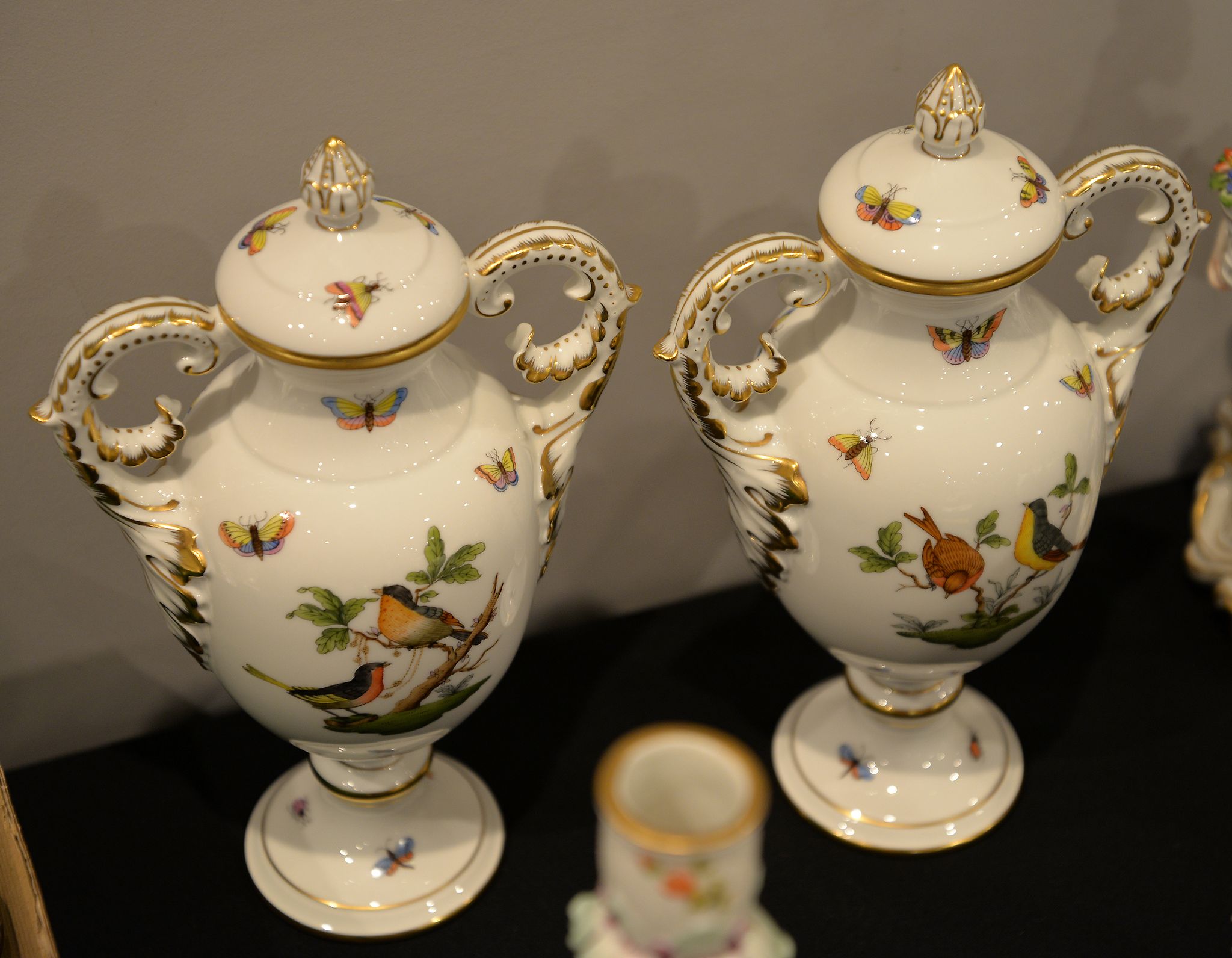 A pair of Herend two handled vases and covers, decorated with birds and insects