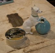 An English porcelain model of a terrier with a ball of wool; and a pot lid