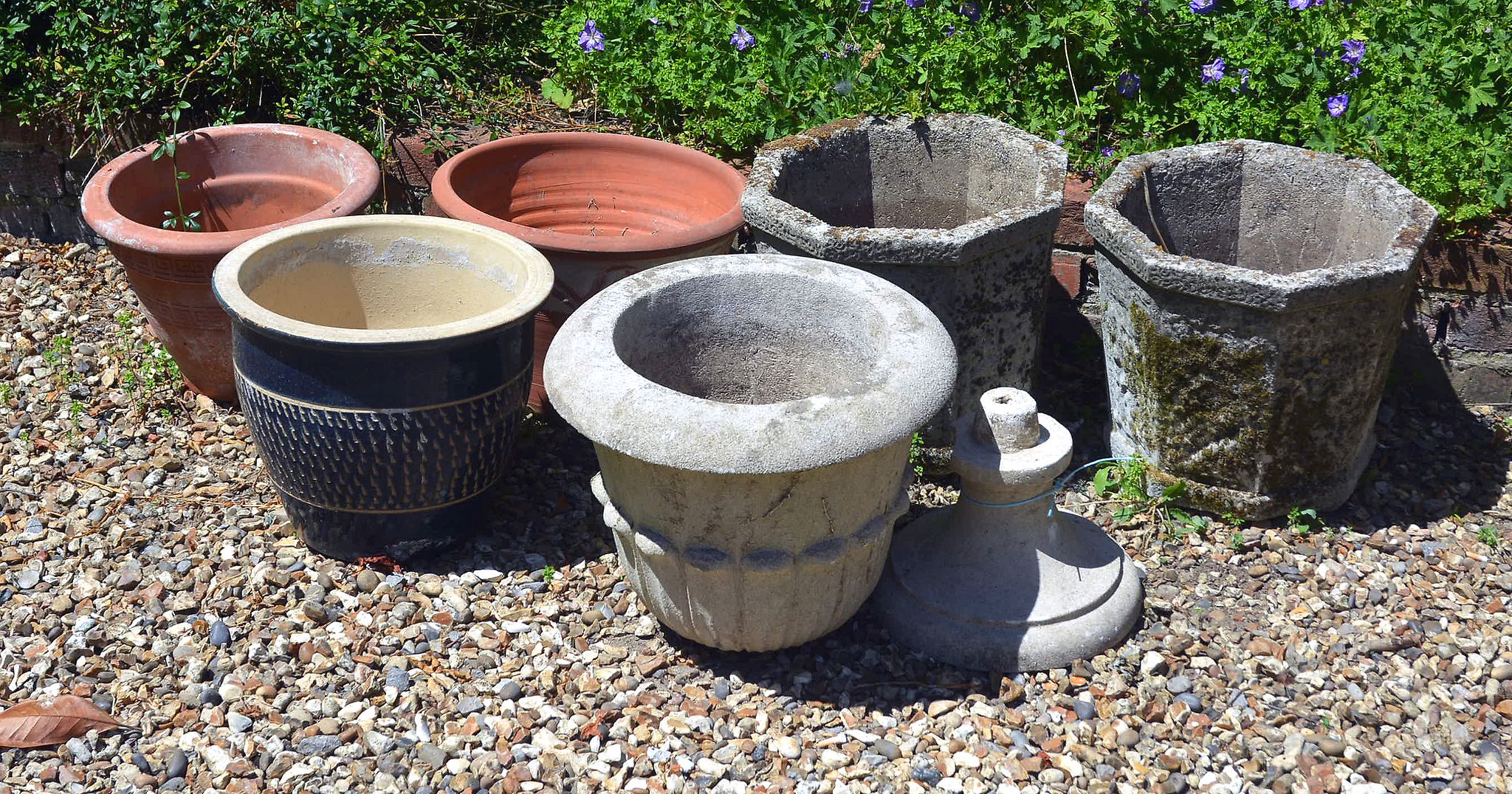 A pair of stone composition hexagonal urns; two further urns and three.