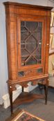 An oak and walnut corner cupboard on associated stand