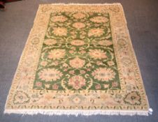 A modern Chinese rug, woven in shades of cream, green, and pink