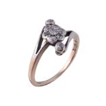 A 1920s diamond cluster crossover ring, set with a cluster of eight cut diamonds, stamped 18ct,