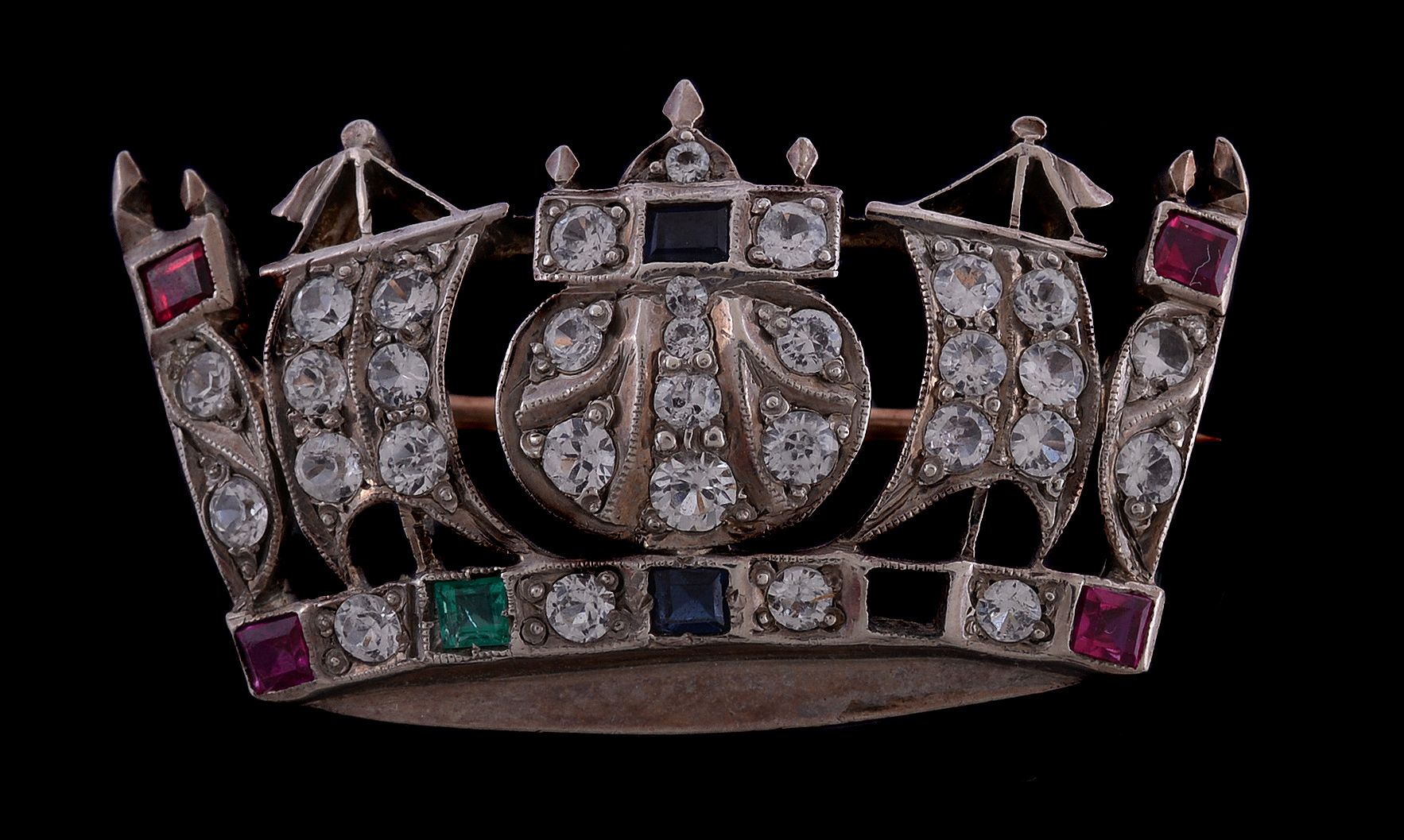 A white spinel, synthetic sapphire and ruby Naval coronet brooch, set with circular cut white