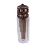A late 19th century facetted glass, gilt metal and garnet set cylindrical scent phial or smelling