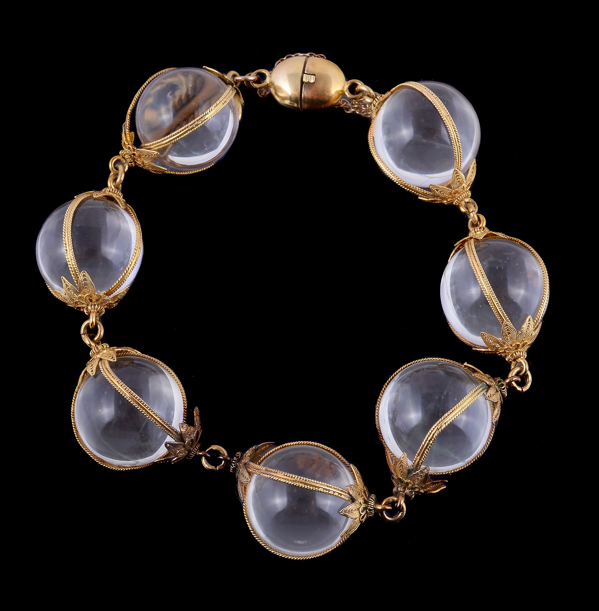 A 19th century adapted rock crystal bracelet, the polished rock crystal spheres encased in filigree