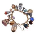A gold coloured charm bracelet, the fancy link bracelet with various attached charms, including a