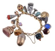 A gold coloured charm bracelet, the fancy link bracelet with various attached charms, including a