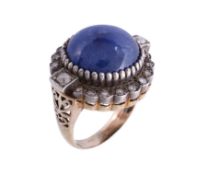 A sapphire and diamond ring, the central circular cabochon within a surround of eight cut and old