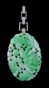 A 1950s jadeite jade and diamond pendant, the oval jadeite jade panel carved with foliage,