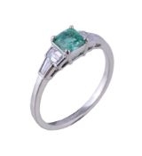 An emerald and diamond ring, the square cut emerald claw set between baguette cut diamonds,