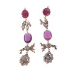 A pair of red stone and diamond earrings, the oval cut red stones between panels set with lasque