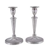 A pair of silver candlesticks by Roberts & Dore Ltd., London 1973, with oval beaded sconces, urn