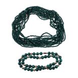 A multi strand malachite bead necklace, the seven strands of uniform malachite beads with gold