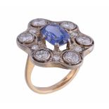 A sapphire and diamond ring, the central oval cut sapphire claw set within a surround of brilliant