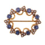 A sapphire and seed pearl brooch, the oval openwork panel set with circular cut sapphires and