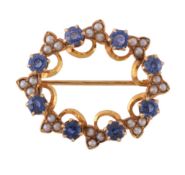 A sapphire and seed pearl brooch, the oval openwork panel set with circular cut sapphires and