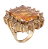 A citrine cluster ring, the rectangular cut citrine claw set within a surround of circular cut