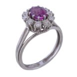 A 1970s pink sapphire and diamond cluster ring, the central oval cut pink sapphire claw set within