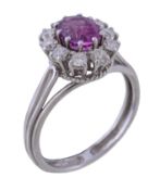 A 1970s pink sapphire and diamond cluster ring, the central oval cut pink sapphire claw set within