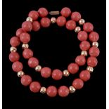 A coral bead necklace, the single strand necklace composed of uniform polished coral beads with