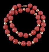 A coral bead necklace, the single strand necklace composed of uniform polished coral beads with
