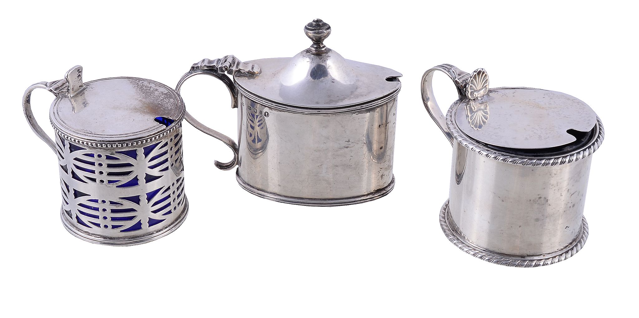 Three silver mustard pots, to include: a late Victorian circular drum mustard pot by John William