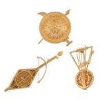 Three gold coloured brooches, to include two musical instruments, and a filligree gold shield, 30g