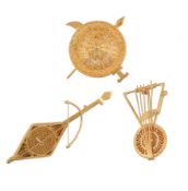 Three gold coloured brooches, to include two musical instruments, and a filligree gold shield, 30g