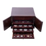 A hardwood collector's coin cabinet, ten trays pierced for coins of various sizes, double-doors,