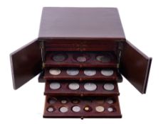 A hardwood collector's coin cabinet, ten trays pierced for coins of various sizes, double-doors,