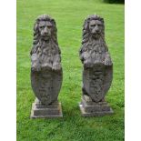 A pair of stone composition pier finials modeled as armorial lions A pair of stone composition