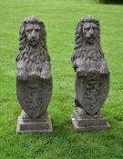 A pair of stone composition pier finials modeled as armorial lions A pair of stone composition